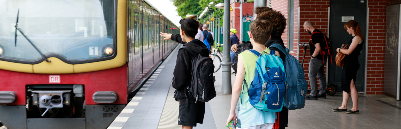 Schüler warten auf einfahrende S-Bahn