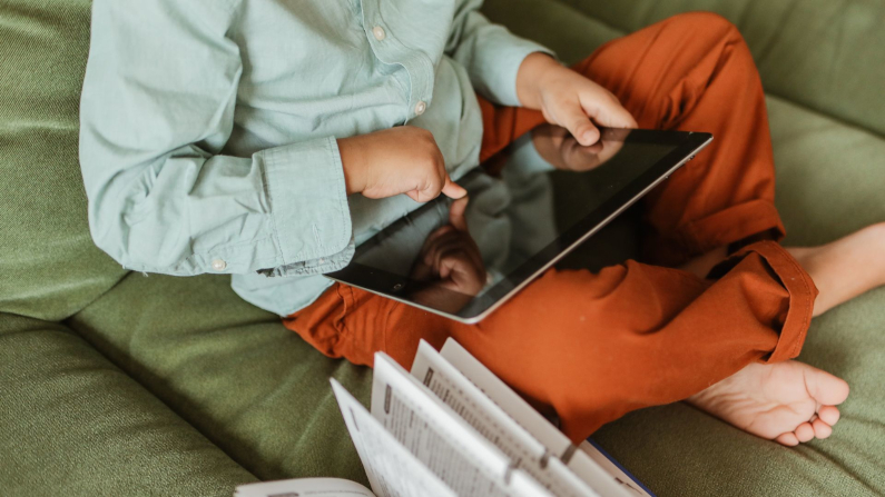 Sitzendes Kind bedient ein Tablet
